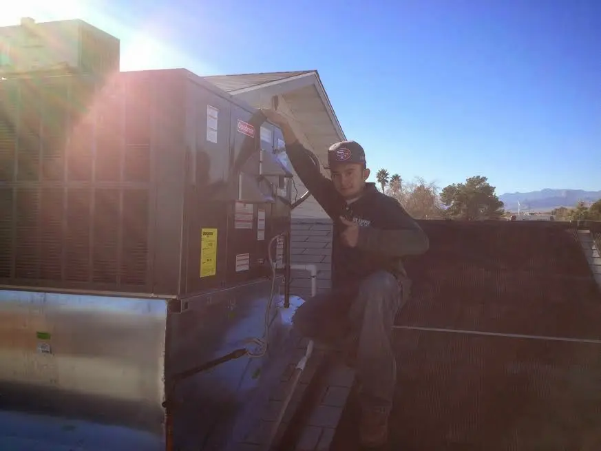 HVAC technician performing HVAC Inspection on a rooftop unit in Nelson